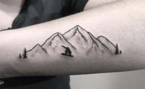 Snowboarding in front of a mountain tattoo